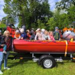 Nauczycielka z dziećmi przy strażackiej motorówce