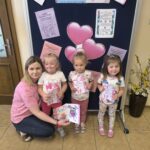 Nauczycielka z dziewczynkami prezentuje ulotki