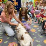 Piesek podaje łapkę dziewczynce