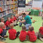 Przedszkolaki witają się z maskotką