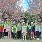 Uczestnicy wycieczki wśród kwitnących drzew