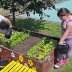 dzieci podlewają rośliny