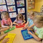 Dzieci dotykają kolorowego ryżu