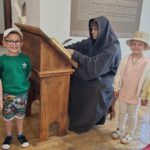 Dzieci przy figurze mnicha