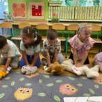 Dzieci robią masaż serca swoim misiom