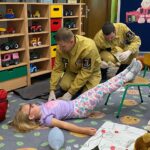 Dziewczynce ratownik udziela pomocy przy omdleniu