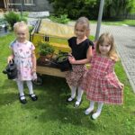 Dziewczynki podlewją warzywa w szklarni