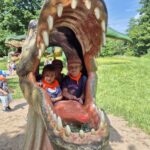 Dziewczynki wyglądają z paszczy dinozaura