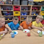 Przedszkolaki barwią wodę za pomocą farby