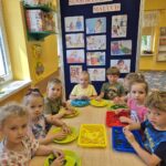 Przedszkolaki dotykają kolorowy makaron