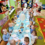 Przedszkolaki z oddziału Żuczki przy stole ze smerfowymi smakołykami