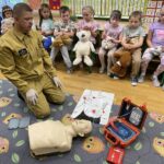 Strażak prezentuje działanie aparatu do RKO