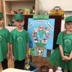 dzieci przy tablicy z plakatem