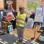 Chłopiec pokazuje jak należy przejść na drugą stronę