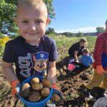 Chlopiec-pokazuje-swoje-wiadereczko-z-ziemniakami