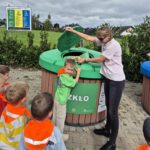 Chłopiec wyrzuca śmieci do kosza