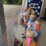 Dzieci z oddziału Krasnoludki odbijają noskiem z kolorowego papieru kropki na folii