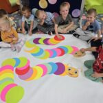 Dzieci z oddziału Krasnoludki układają kolorową gąsienicę z dużych kropek