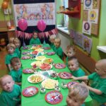 Dzieci z oddziału Żuczki przy stole z poczęstunkiem