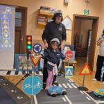 Dziewczynka pokazuje jak policjant kieruje ruchem