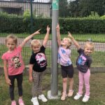 Dziewczynki pokazują piktogram zbiórki ewakuacji