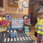 Dziewczynki rzucają piłkę przez jezdnię