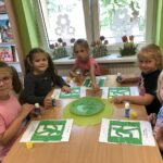 Dziewczynki wyklejają piktogram