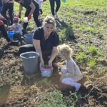 Pani-zbiera-z-dziewczynka-do-wiadereczka-ziemniaki