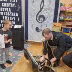 chłopiec odgaduje instrument ukryty w futerale