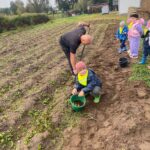 Chłopiec pokazuje wiaderko z zimniakami