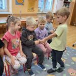 Chłopiec wręcza dzieciom listki, zakładki