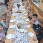 Dzieci siedzą przy stole w oczekiwaniu na degustację chleba