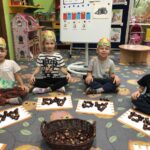 Dzieci układają literki z kasztanów