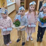 Dzieci z kwiatkiem i czekoladkami dla policjantów