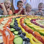 Dzieci-zajadaja-owoce-i-warzywa-z-kolorowej-teczy