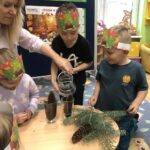 Dziecko nalewa wodę do szklanki z szyszką