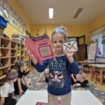 Dziewczynka dobiera list do odpowiedniej skrzynki