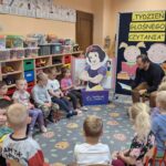 Pan Radosław czyta dzieciom bajkę.