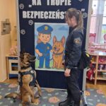 Pies wykonuje komendy policjantki