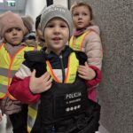Chłopiec przymierza kamizelkę policyjną