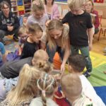 Dzieci otwierają prezent od krasnala