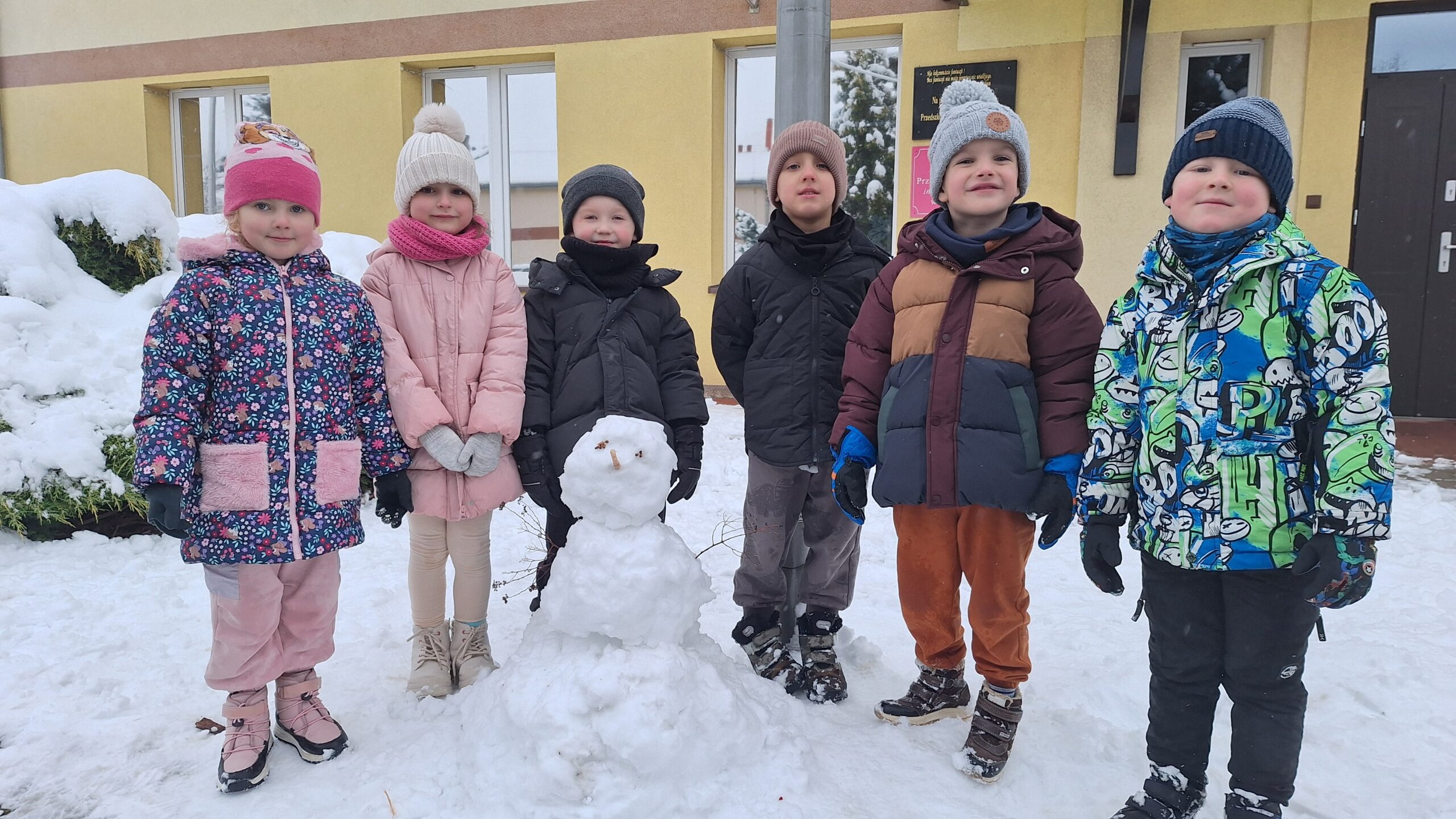 Dzieci z oddziału BIedronek z bałwanem