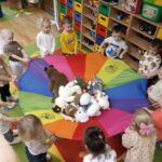 Dzieci z oddziału Żuczki podczas zabawy z chustą Klanza i swoimi misiami