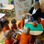 Dzieci z oddziału Żuczki słuchają wiadomości na temat rozwoju dyni
