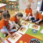 Dzieci z oddziału Żuczki wykonują dla dyni uśmiech z kasztanów