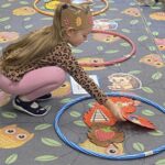 Dziewczynka kładzie listek z obrazkiem do obręczy