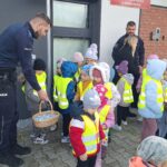 pan Policjant częstuje dzieci cukierkami