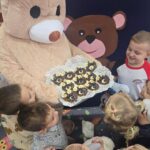 Pluszowy miś odwiedza dzieci z odddziału Krasnoludki ze słodką przekąską