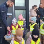 Policjant częstuje dzieci cukierkami