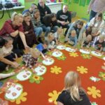 Przedszkolaki układają żołędzie na szablonach drzewa